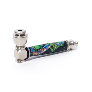 May include: A silver metal smoking pipe with a black and green design. The design features a colorful alien character.