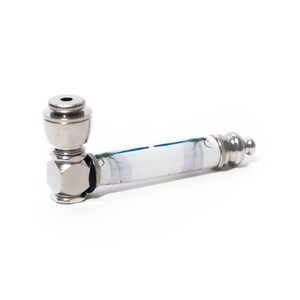 May include: A silver metal pipe with a white and blue patterned design. The pipe has a cylindrical body with a decorative end and a bowl-shaped head. The design on the body features a dragonfly.
