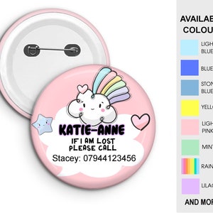 May include: Pink round button with a cartoon cloud and rainbow. The text on the button reads "KATIE-ANNE IF I AM LOST PLEASE CALL Stacey: 07944123456".