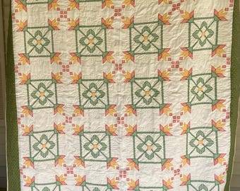 Pode incluir: Um edredom branco com um padrão geométrico verde, amarelo e vermelho. O edredom é orlado com uma borda verde.