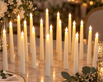 Pode incluir: Uma coleção de velas cônicas em tom branco sujo com chamas LED brilhantes dispostas sobre uma superfície de mármore. Cada vela fina apresenta um corpo cilíndrico liso e uma luz quente e constante no topo para decoração de mesa.