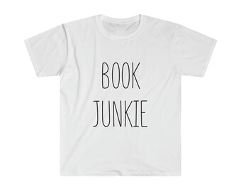 以下が含まれることがあります： 前面に黒字で「BOOK JUNKIE」と書かれた白いTシャツ。シンプルなフォントで書かれています。クルーネックと半袖で、普段使いに適しています。