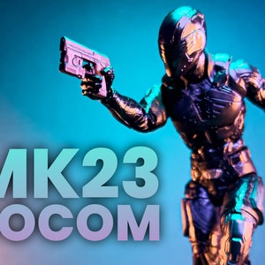 May include: A black action figure with a silver helmet and a gun in its hand. The figure is posed in a running stance. The text "MK23 SOCOM" is in the foreground.
