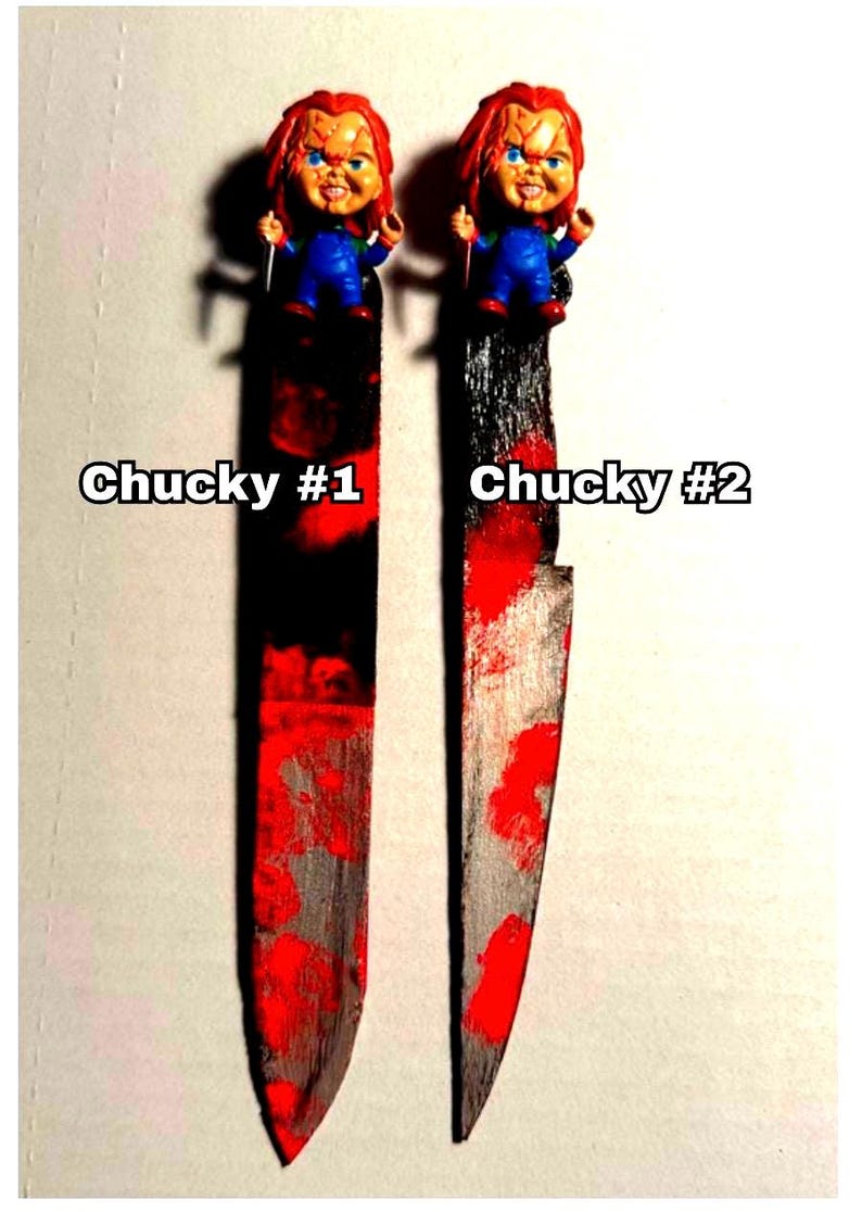 includes : A handmade Chucky knife bookmark. The bookmark is approximately 8 inches tall and features two hand painted design resembling  bloody knifes . A small Chucky figurine is attached to the top. The colors include black, red, and silver paint splatters on a black knife shaped bookmark. The bookmark is a unique and collectible item for horror fans. choose version one or version two these are unique so they will vary every time I make them