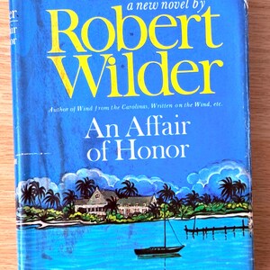 May include: A vintage book cover for "An Affair of Honor" by Robert Wilder. The cover features a blue background with yellow text. A tropical scene with palm trees, a house, and a sailboat is depicted.