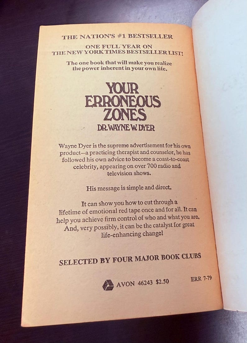 May include: Open book page with text from "Your Erroneous Zones" by Dr. Wayne Dyer. The book is a bestseller, with text in a serif font on an aged paper background. The book's title is in a bold, stylized font.
