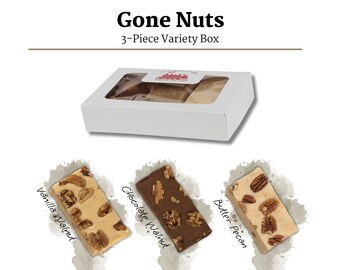 May include: A white box with a clear window showing three pieces of fudge. The fudge is labeled "Vanilla Walnut", "Chocolate Walnut", and "Butter Pecan".
