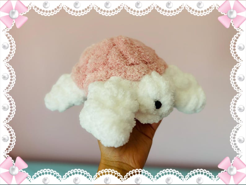 May include: A plush turtle toy with a pink shell and white body. The turtle has a soft, textured appearance and a small black eye. The toy is designed to be cuddly and is likely intended for children.