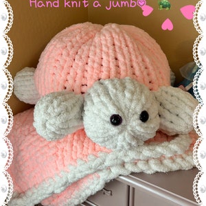 Peut inclure: Une couverture de tortue géante en tricot rose et blanc. La couverture est faite d'un fil doux et moelleux et a un visage de tortue mignon.