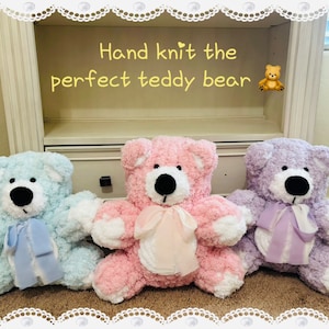May include: Three hand-knitted teddy bears, one light blue, one pink, and one lavender, each with a white bow around its neck. The bears are sitting on a shelf with the text "Hand knit the perfect teddy bear" above them.