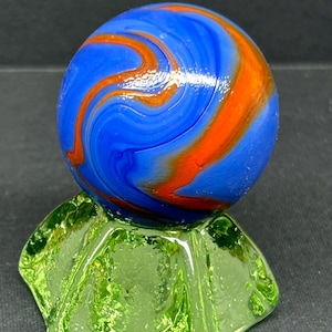 Uranium glass marble stand with large blue and orange marble