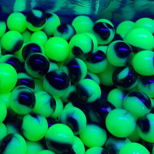 May include: A collection of round, spherical beads featuring a vibrant neon green base color with swirling black patterns throughout. Each bead has a smooth, glossy finish and a uniform shape, creating a high-contrast visual effect across the group.