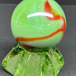 Uranium glass marble stand with large green and red  marble