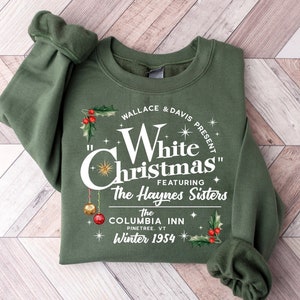 Può includere: Una felpa verde con una stampa grafica bianca che recita "Wallace & Davis Present "White Christmas" Featuring The Haynes Sisters The Columbia Inn Pinetree, VT Winter 1954".