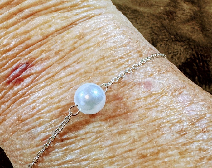 Single, solitary centered pearl bracelet with chain link. Lobster claw closure. 7 1/4” in diameter. Handmade