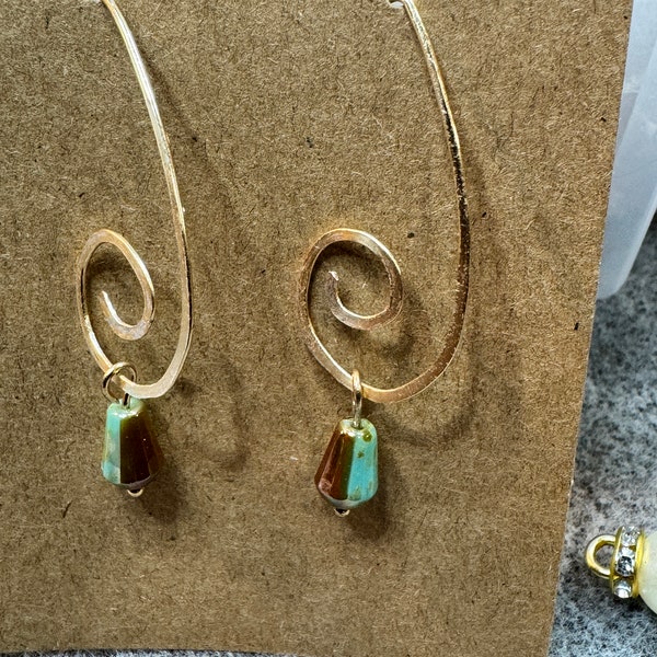 V-shaped gold swirl wire earrings with a small cone-shaped green picasso drop bead. 2” dangle and Handmade. Gifts for her. Bohemian earrings