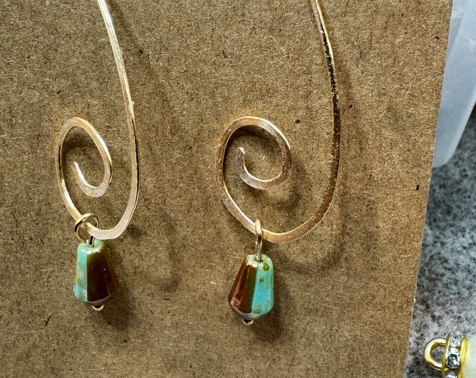 V-shaped gold swirl wire earrings with a small cone-shaped green picasso drop bead. 2” dangle and Handmade. Gifts for her. Bohemian earrings
