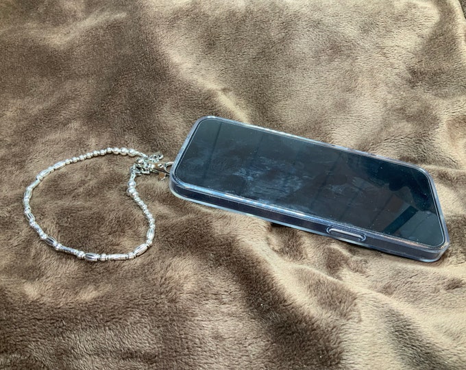 Handmade Phone wristlet lanyard, with silver beads and charms and a large silver lobster claw closure. It measures around 10”.