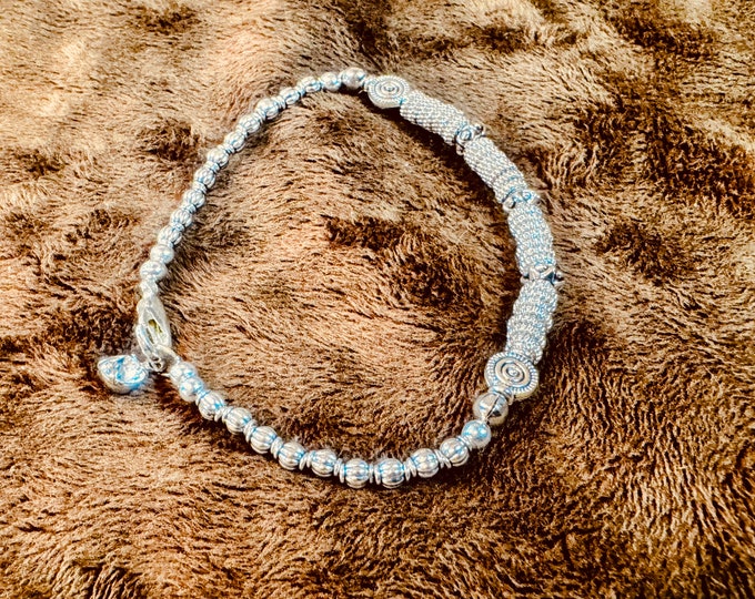 Silver faceted spacers and round twirl beaded bracelet on hard wire with oval-shaped silver beads on regular wire. Rhinestone charm. Set