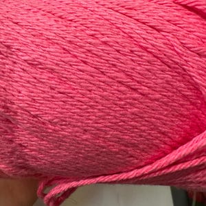 May include: A skein of pink yarn, a popular material for knitting and crocheting.