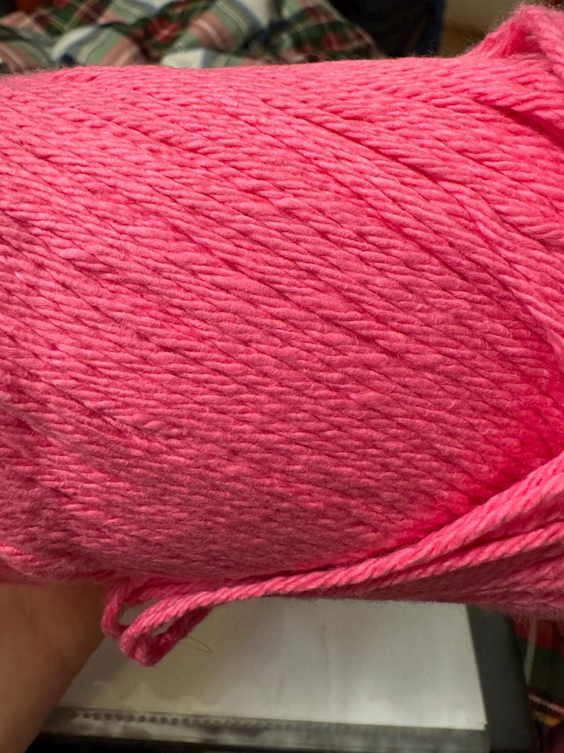 May include: A skein of pink yarn, a popular material for knitting and crocheting.