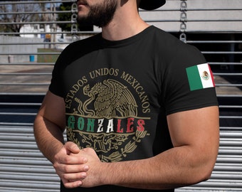 May include: A black t-shirt with a gold and green graphic of the Mexican coat of arms. The text "Estados Unidos Mexicanos" is written in a circle around the graphic. The text "Gonzales" is written below the graphic. A Mexican flag is on the right sleeve of the shirt.