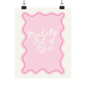 May include: A poster with a light pink wavy border and a solid pink center. The text "Mentally: Out of Office" is written in white cursive script. The poster is held by two black binder clips.