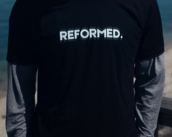 May include: A black t-shirt with a white graphic that says "REFORMED."