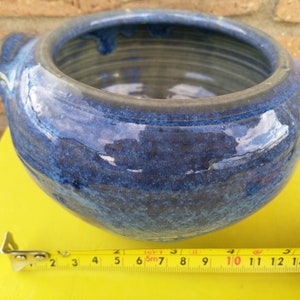 May include: A blue ceramic bowl with a glazed finish and two handles. The bowl is approximately 25 cm in diameter.