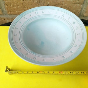 Op de afbeelding: Een lichtblauwe keramische kom met de woorden "Music Makers" rond de rand. De kom heeft een diameter van 25,4 cm.