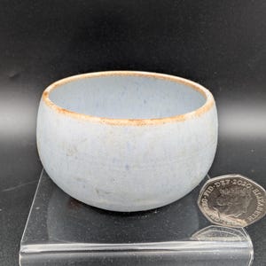 May include: A set of three ceramic mugs with a speckled, matte finish. The mugs are in shades of cream, light gray, and dark gray. Each mug has a simple, minimalist design, perfect for coffee or tea.