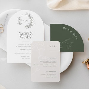 May include: Wedding invitation suite with a green and white color scheme. The main invitation features a floral wreath with the initials "N&W" and the names "Naomi & Wesley". The details card includes the ceremony and accommodation information. The RSVP card says "Be our guest".