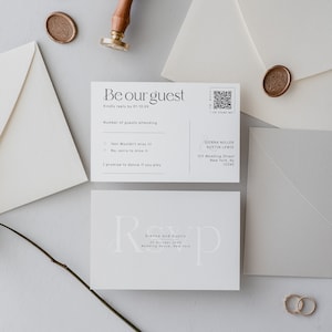 May include: A white wedding invitation with a black and white design. The invitation features the text "Be our guest" and a QR code. The invitation also includes the names Sienna Miller and Austin Lewis, the wedding date, and the wedding venue.