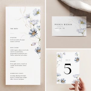 May include: A wedding menu card with a floral design featuring blue flowers and green leaves. The menu includes starters, main course, dessert, and sommelier's choice. The text on the card reads "The Menu", "Starters", "Main Course", "Dessert", and "Sommelier's Choice".