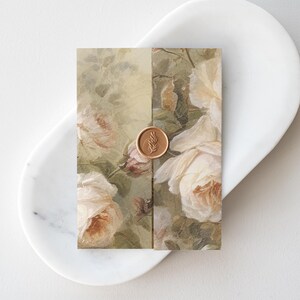 May include: A white envelope with a floral pattern and a gold wax seal with a leaf design.
