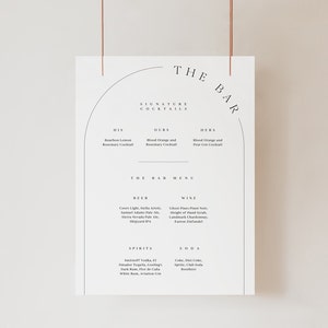 May include: A white sign with black text listing the bar menu for a wedding. The sign has a black arch at the top with the words "The Bar" in a black font. The menu includes signature cocktails, beer, wine, spirits, and soda.