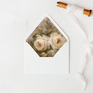 May include: White envelope with a floral design on the flap. The design features two pale pink roses with a brown background.