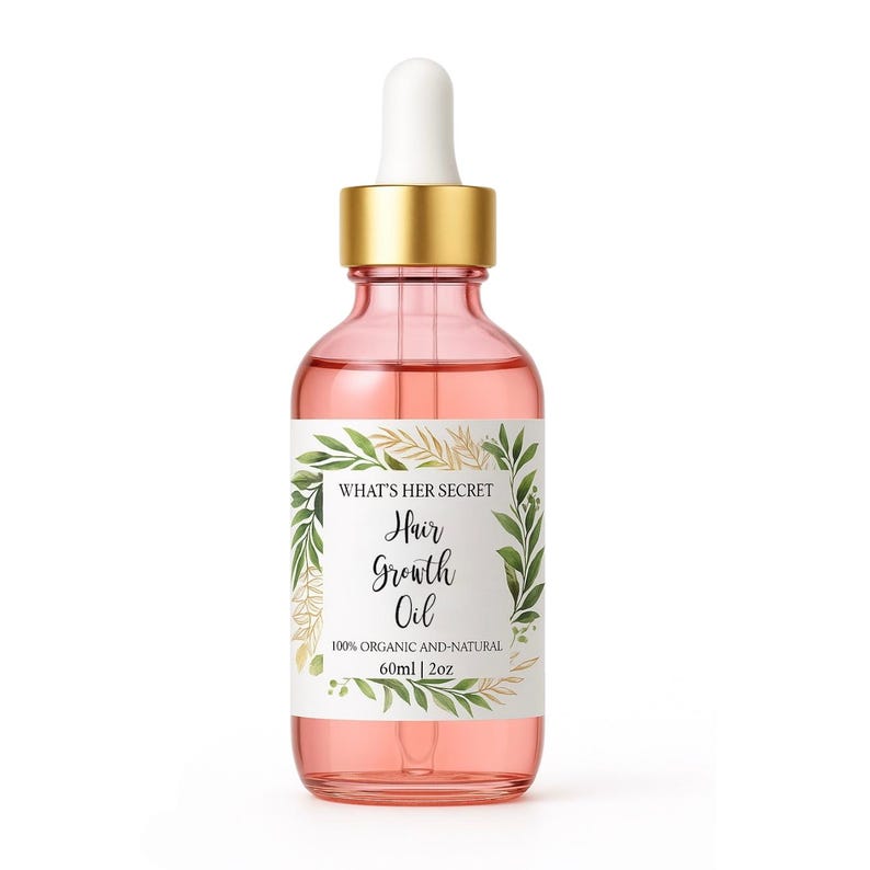 K&ouml;nnte beinhalten: Eine durchsichtige Glasflasche mit goldenem Deckel und Tropfer, gef&uuml;llt mit einer rosa Fl&uuml;ssigkeit. Die Flasche hat ein wei&szlig;es Etikett mit gr&uuml;nen und goldenen floralen Designs und dem Text "WHAT'S HER SECRET Hair Growth Oil 100% ORGANIC AND-NATURAL 60ml | 2oz".