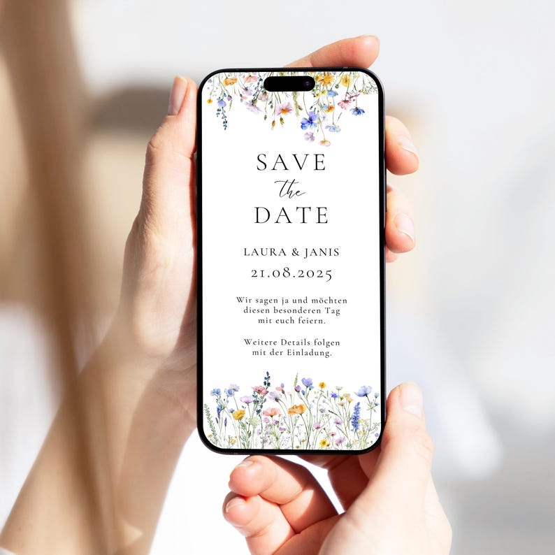 May include: A floral save the date card on a smartphone screen. The card is white with black text that reads "Save the Date", "Laura & Janis", and "21.08.2025". The text below the date reads "Wir sagen ja und m&ouml;chten diesen besonderen Tag mit euch feiern. Weitere Details folgen mit der Einladung."