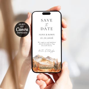 Könnte beinhalten: Ein Smartphone zeigt eine digitale Save-the-Date-Karte mit dem Text SAVE THE DATE, ALINA & ROBIN, 21.10.2026 sowie deutschem Text. Das Design zeigt eine Aquarellillustration von Bergen und herbstlichen Bäumen am unteren Rand und ein schwarzes Abzeichen.