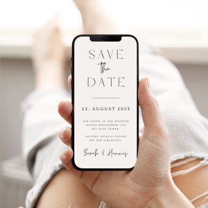 May include: A white save the date card on a smartphone screen. The card has black text that reads "Save the Date", "22. August 2025", "Wir sagen Ja und m&ouml;chten diesen besonderen Tag mit euch feiern", "Weitere Details folgen mit der Einladung", and "Sarah & Hannes".