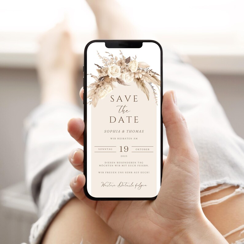 May include: A digital save the date card with a beige background and a floral design. The text reads "Save the Date" with the names "Sophia & Thomas" and the date "Sunday, 19th October 2035".