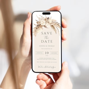 May include: A save the date card with a beige background and a floral design. The text reads "Save the Date" with the names "Sophia & Thomas" and the date "Sunday, 19th October 2025".