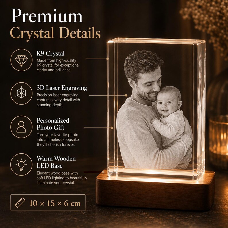 May include: A rectangular K9 crystal block featuring a 3D laser-engraved image of an adult holding a baby. The crystal sits on a rectangular wooden LED base. Text on the image includes Premium Crystal Details and dimensions of 10 x 15 x 6 cm.