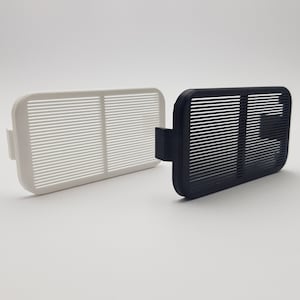 Könnte beinhalten: Zwei rechteckige Luftfilter, einer weiß und einer schwarz, mit einem Gittermuster. Beide Filter haben eine kleine Lasche an der Seite.