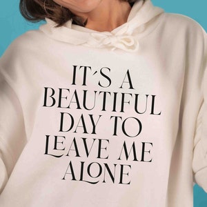 Könnte beinhalten: Weißer Hoodie mit schwarzem Text, der "Es ist ein wunderschöner Tag, um mich in Ruhe zu lassen." lautet.
