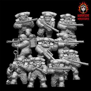 Puede incluir: Un conjunto de figuras en miniatura grises de soldados barbudos con equipo táctico, cada uno sosteniendo un rifle. Las figuras son detalladas, con mochilas y cascos. El logotipo de Hardcore Miniatures es visible.