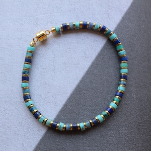 May include: A blue and turquoise gemstone bracelet with gold accents. The bracelet has a magnetic clasp.