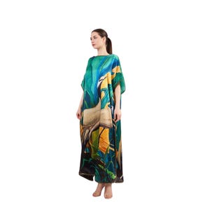 May include: A long, flowing green and blue dress with a white bird and tropical leaf print. The dress has a loose, comfortable fit and is perfect for a summer day.