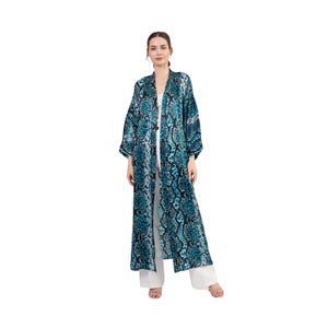 May include: A long, blue and black patterned robe with a relaxed fit and long sleeves. The robe has a snakeskin print and is open in the front.